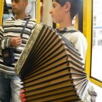 Street kid on a train playing for his supper