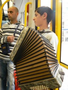 Street kid on a train playing for his supper