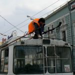 Trolley driver reconnecting her cable arms