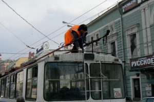 Trolley driver reconnecting her cable arms