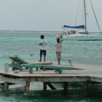 Local kids fishing as tourists sail past
