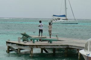Local kids fishing as tourists sail past