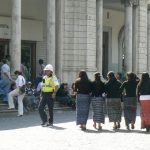 Local girls arm-in-arm and policeman in British (?) helmut