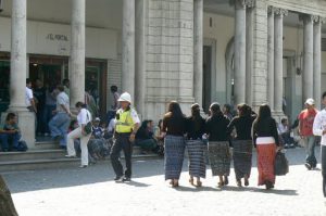 Local girls arm-in-arm and policeman in British (?) helmut