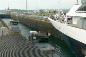 Ship passing through the Panama Canal pulled by locomotives