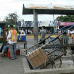 Waiting at the local bus stop among food vendors