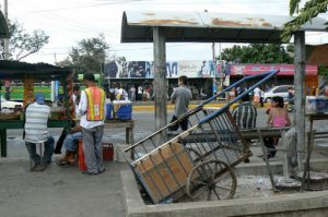 Waiting at the local bus stop among food vendors