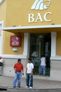 Money changers (holding wads of cash) in front of Central