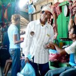 Market faces: butcher greets a friend