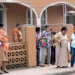 Church service ending; note high guard fence