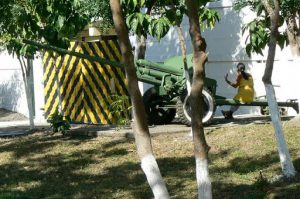 A woman sitting on a cannon (left over from the