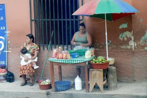 Another fruit vendor with young mother nursing her child