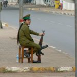 Female soldier on duty with shoes off