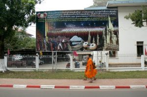 Monks walking past Laotian historical painting