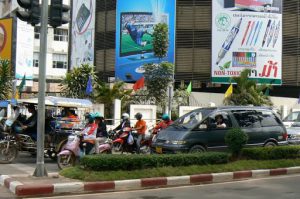 Busy main road with traffic, billboards and anniversary flags