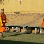 Boy monks carrying offerings at Pha That Luang national monument