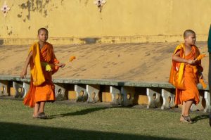 Boy monks carrying offerings at Pha That Luang national monument
