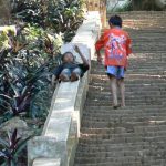Kids sliding down walls on the stairs up to Phou