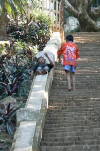 Kids sliding down walls on the stairs up to Phou