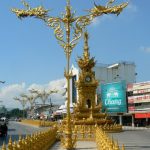 Golden clock tower and decorative standards in central city; built by