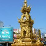 Golden clock tower and decorative standards in central city;  built
