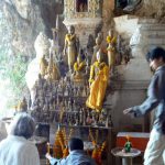 Lighting candles at the shrine in the cave