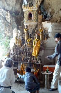 Lighting candles at the shrine in the cave