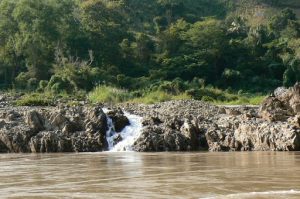 A small waterfall runs through the rocky embankment