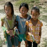 Little girls waiting to sell woven wrist bands; the locals