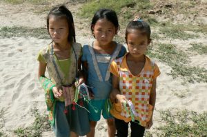 Little girls waiting to sell woven wrist bands; the locals