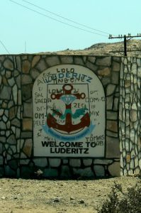 Behind the graffiti is a welcome to Luderitz,  a cargo