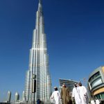 Emirati men walk past Burj Dubai, the world's tallest tower,