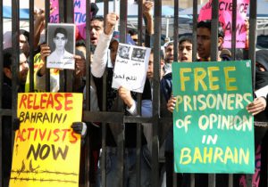 Bahraini Shiites hold banners and portraits of prisoners during a