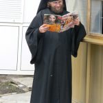 Ukraine, Kiev - Pechersk Lavra; monk reading magazine