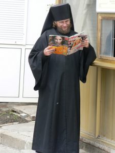 Ukraine, Kiev - Pechersk Lavra; monk reading magazine