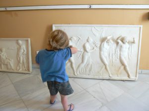 Greece, Corfu Island, Achilieion Palace; little visitor imitating sculpture pose
