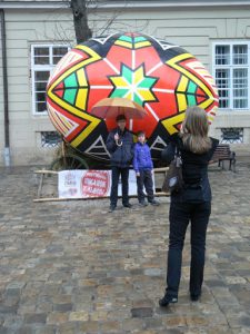 Ukraine, Lviv - central city tourists with oversized Easter egg next