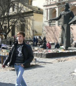 Ukraine, Lviv - Dominican Cathedral in background; foreground are booksellers and