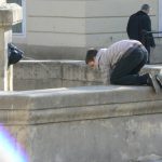 Ukraine, Lviv - boy fetching coins out of a fountain