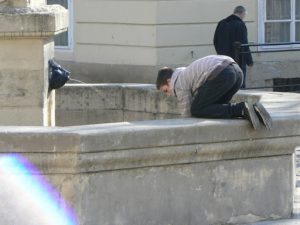 Ukraine, Lviv - boy fetching coins out of a fountain