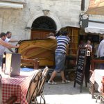 Moving a grand piano through the narrow streets--carefully