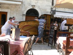 Moving a grand piano through the narrow streets--carefully