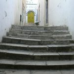 Ancient worn steps lead to a typical arched doorway.