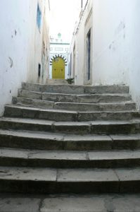 Ancient worn steps lead to a typical arched doorway.