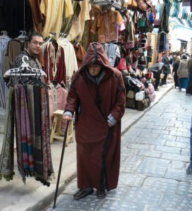 Old man plodding his way along a souq,