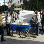 Boys selling coconut meat in front of medina entry.