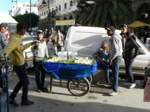 Boys selling coconut meat in front of medina entry.