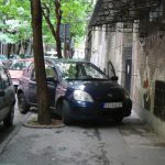 Outside the museum some people park their cars helter-skelter with