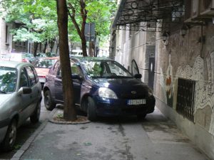 Outside the museum some people park their cars helter-skelter with