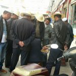 Tibet, Lhasa: buyers gather around a fungi seller